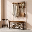 Kapstok met bruine houten planken, 11 haken, zitbank en schoenenrek. Schoenen en kleding hangen eraan.
