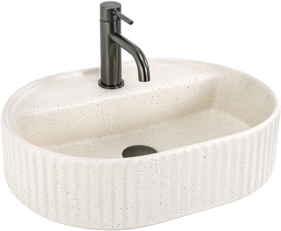 Lavabo ovale en céramique de couleur crème à nervures verticales, avec un robinet gris foncé, isolé sur fond blanc.