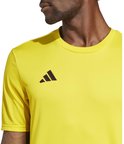Close-up van de linkerschouder en borst van een geel Adidas sportshirt met zwart Adidas logo.