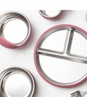 Drie roze metalen schalen en een verdeeld bord met roze rand, op een witte achtergrond.