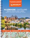 Image colorée d'une ville au bord d'une rivière avec une église, entourée de collines.