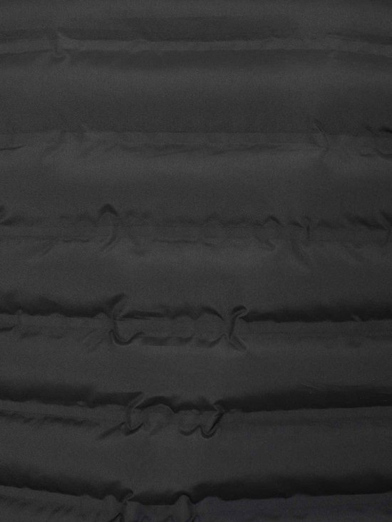Detail van de horizontale, gewatteerde textuur van de zwarte bodywarmer van Bjørnson.
