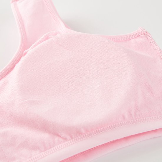 Detail van een roze meisjes sportbeha, met de zachte katoenen stof en naden zichtbaar.