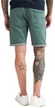 Achterkant van groene slim fit stretch denim shorts met opgerolde zomen en vijf zakken.