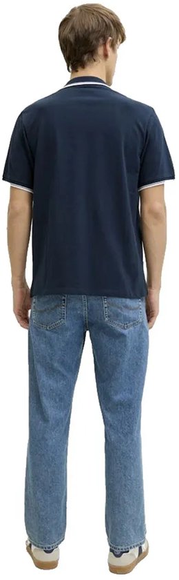 Achterkant man in donkerblauw poloshirt met witte kraag- en mouwstrepen, en blauwe jeans.