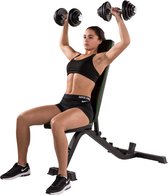 Vrouw met sport-bh en korte broek zit op een zwarte trainingsbank met groene accenten en drukt dumbbells omhoog.