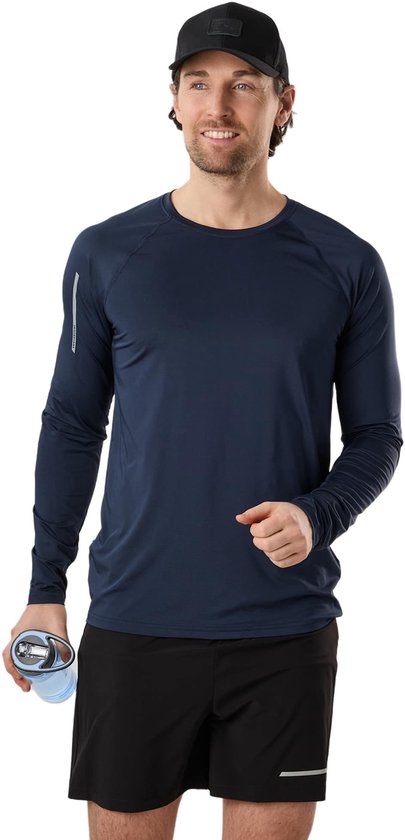 Homme souriant portant un t-shirt d'entraînement bleu marine à manches longues et un short noir, avec une casquette noire et une gourde bleue.