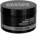 Zwarte pot met 'Redken Brews NYC Grooming' op het deksel. Bevat 'Clay Pomade Pommade d'argile'.