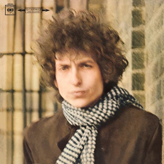 Bob Dylan met krullend bruin haar en een ruitjes sjaal om zijn nek, draagt een bruine jas. Columbia logo linksboven.