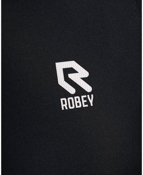 Close-up van het witte Robey logo op een zwarte poloshirt.