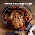 Geglaceerde geroosterde kip met geroosterde aardappelen, wortelen en citroen in een glazen schaal.