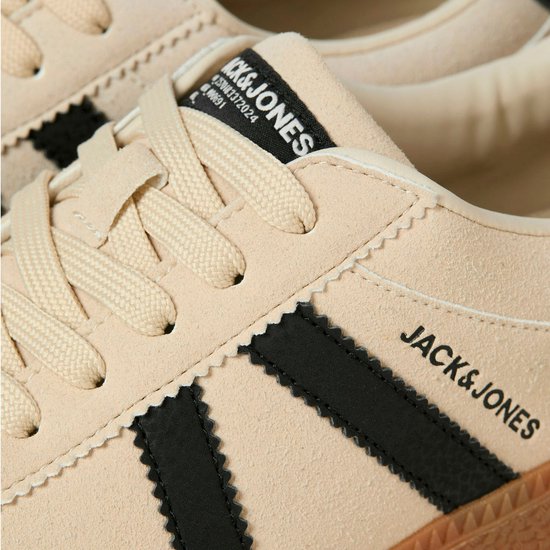 Detail van beige suède sneaker met zwarte strepen en Jack & Jones logo.