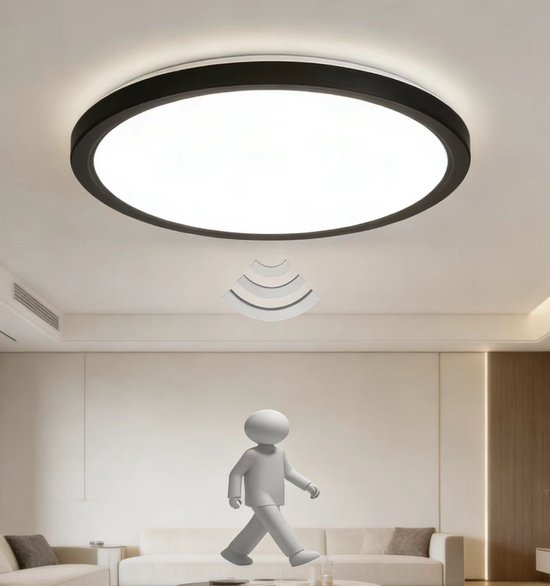 Ronde, platte LED-lamp met zwarte rand, met bewegingssensor pictogram boven een 3D-figuur in een woonkamer.