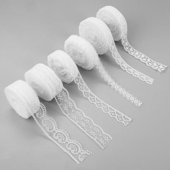 Six rouleaux de dentelle blanche aux motifs variés.
