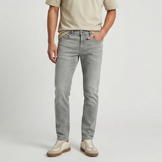 Man met grijze Cars Jeans en beige sneakers. Jeans met regular fit en een lichte wassing.