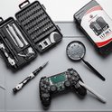 Een open precisieschroevendraaierset met 117 stuks ligt naast een gedemonteerde gamecontroller.