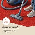 Een stofzuiger op rode kunstgras, met de tekst 'Geschikt voor stofzuiger'.