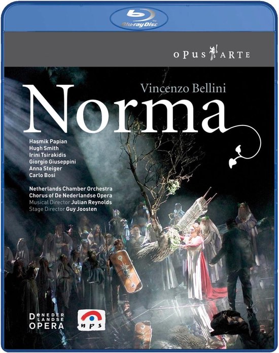 Blu-ray hoes van de opera Norma, met een cast van zangers in kostuums voor een dramatische scène, omlijst door een boom.