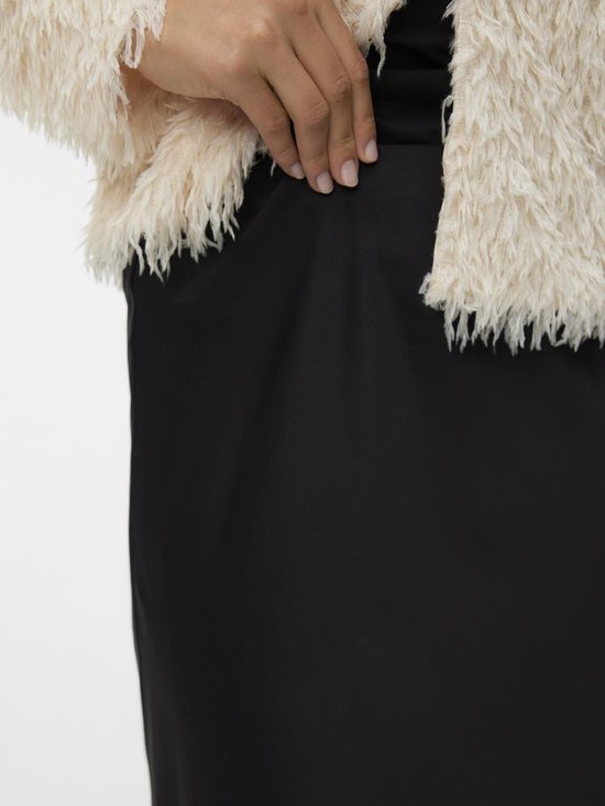 Jupe midi noire en satinée, portée avec un gilet fluffy crème.