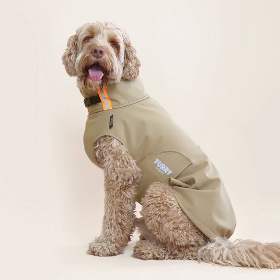 Zittende beige hond in een beige Furry Original softshell hondenjas met oranje accenten. De jas heeft een logo op de zijkant.