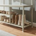 Crèmekleurige, metalen schoenenkast met schoenen op de planken.