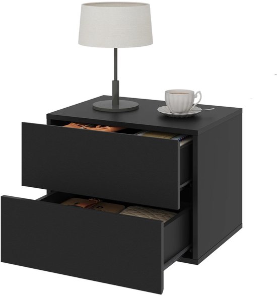 Zwart nachtkastje met twee open lades, een lamp, een mok en schoteltje.