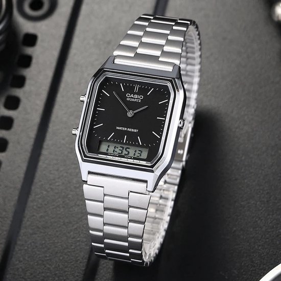 Montre argentée avec bracelet métallique, cadran noir, affichage analogique et numérique, avec bracelet à maillons argentés.