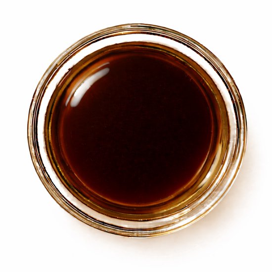 Een glazen potje gevuld met donkerbruine koffieolie.