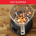 Amandelen vallen in een draaiende, romige substantie in een blenderkan. Tekst: FAST BLENDING.