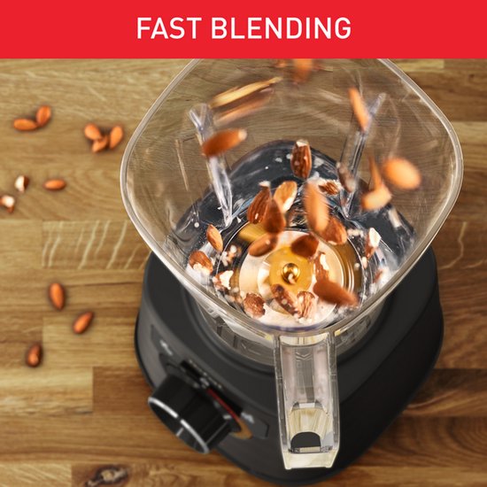 Amandelen vallen in een draaiende, romige substantie in een blenderkan. Tekst: FAST BLENDING.