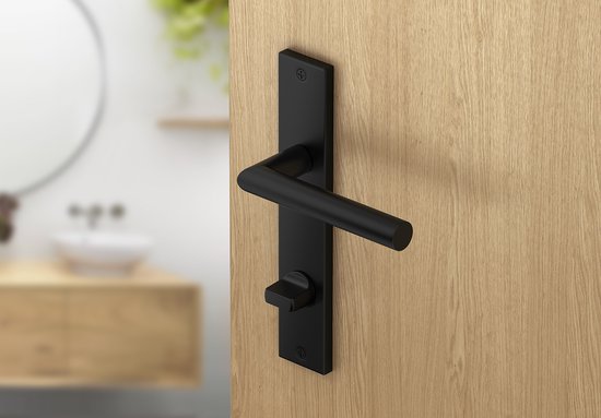 Matzwarte deurgreep met schild, geplaatst op een houten deur, met badkamer op de achtergrond.