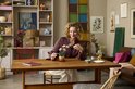 Vrouw met een LEGO orchidee in een pot op een houten tafel.