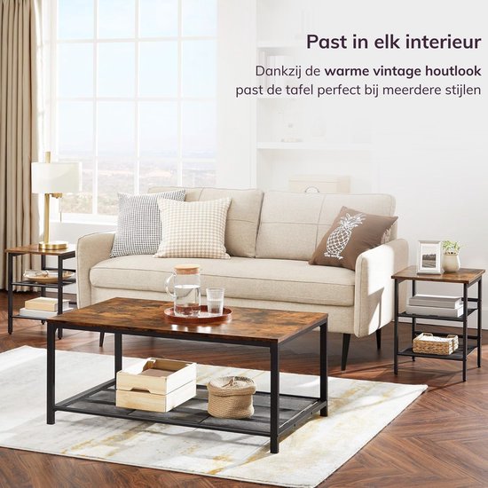 Woonkamer met een bruine bijzettafel naast een bank, met een koffietafel ervoor. De tafel heeft een vintage houtlook.