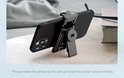 Zwarte smartphone op een zwarte selfie-stick houder op een tafel.