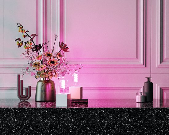 Een decoratieve vaas met bloemen en twee lampen op witte sokkels, badend in roze licht.