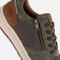 Close-up van een groene sneaker met rits en bruine accenten.