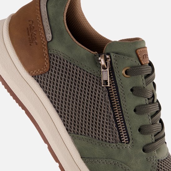 Close-up van een groene sneaker met rits en bruine accenten.
