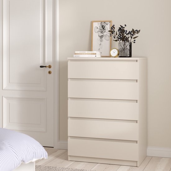 Greeploze taupekleurige ladekast met vijf lades, staand in een slaapkamer naast een deur.