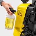 Hand koppelt Karcher schuimlans aan reinigingsmiddelfles voor hogedrukreiniger.