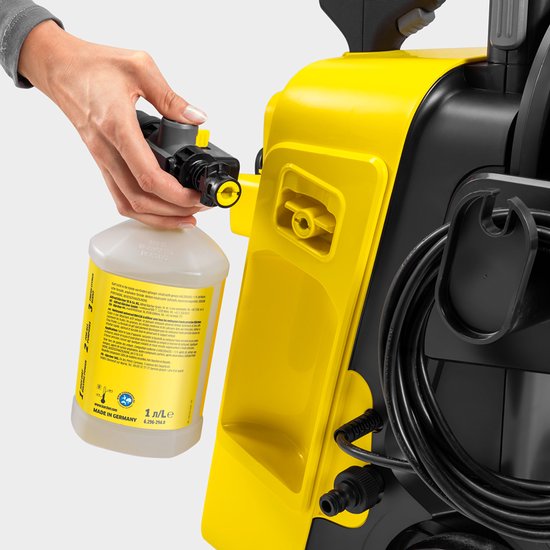 Hand koppelt Karcher schuimlans aan reinigingsmiddelfles voor hogedrukreiniger.