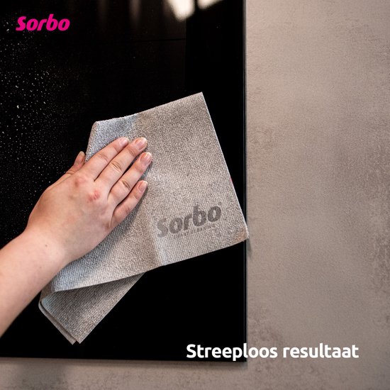 Hand die een grijze Sorbo microvezeldoek gebruikt om een zwarte kookplaat schoon te maken.