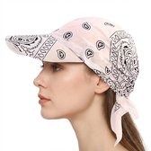Vrouw met witte bandana cap met zwarte paisley print en strik in het haar.