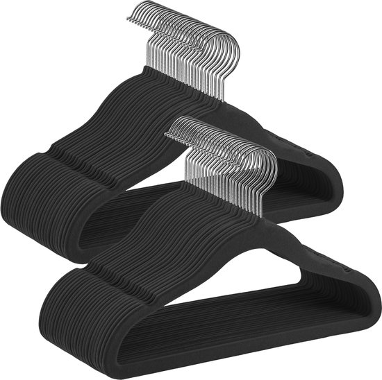 Stapel zwarte fluwelen kledinghangers met zilverkleurige haken.