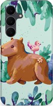 Telefoonhoesje met een bruine capibara met een roze vogel op zijn rug, omringd door groene bladeren en bloemen.