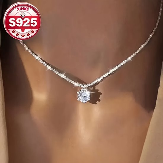 Collier argenté avec une grosse pierre transparente au centre. Logo S925 en haut à gauche.