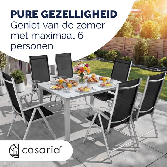 Casaria tuinset met tafel en zes zwarte stoelen, gedekt voor een ontbijt.
