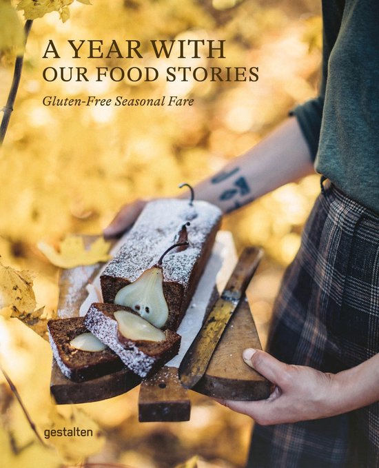 Een jaar met onze food stories, glutenvrije seizoensgerechten. Een cake wordt opgesneden, bestrooid met poedersuiker, met peren er bovenop.