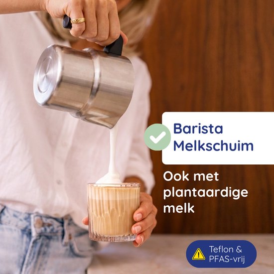 Vrouw giet melkschuim uit zilverkleurige kan in een glas met koffie.