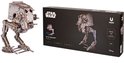 Houten AT-ST Walker model op de voorgrond en de verpakking op de achtergrond, met het Star Wars logo en productinformatie.