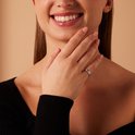 Mannequin portant une bague argentée sertie de zirconiums à l'annulaire.